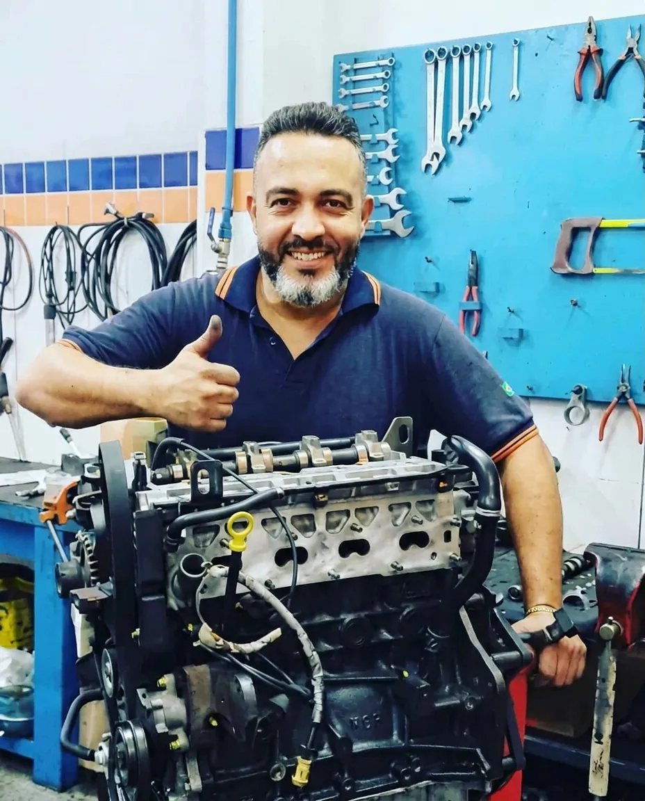 Martins, proprietário da Mecânica Martins, ao lado de um motor na oficina