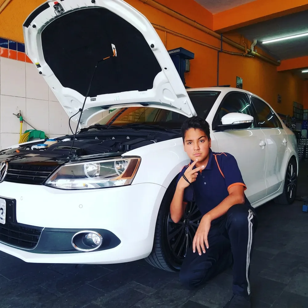 Mecânico da equipe da Mecânica Martins ao lado de um veículo em manutenção